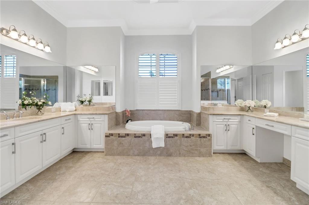 3260 Atlantic Circle Naples, FL 34119 - Photo 17 of 50 a large white bathroom with a sink a large mirror and a bathtub