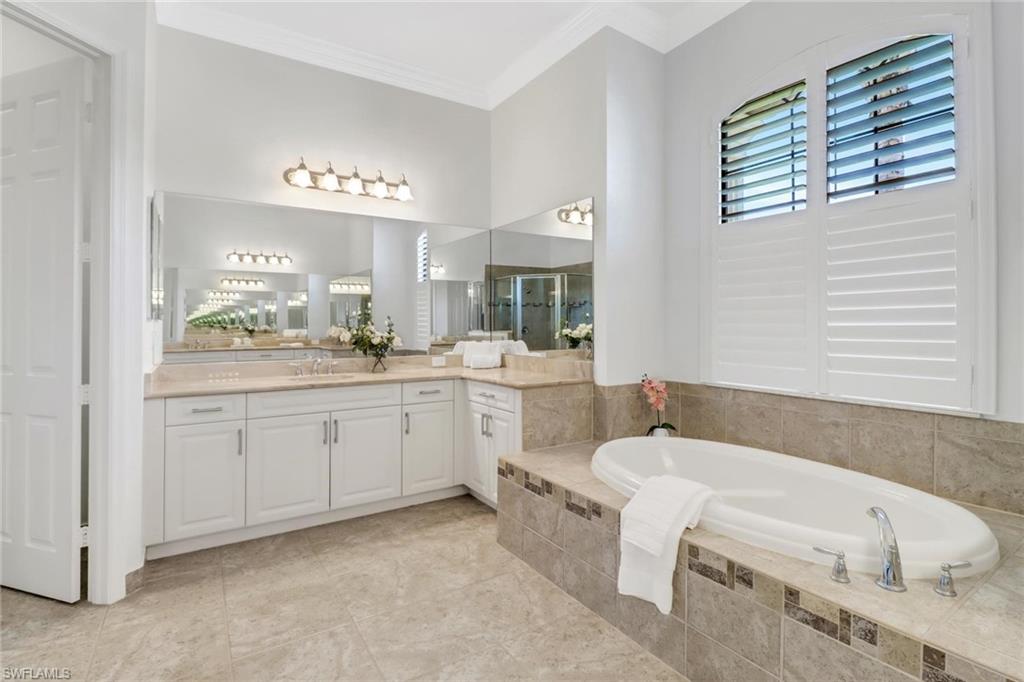 3260 Atlantic Circle Naples, FL 34119 - Photo 18 of 50 a bathroom with a sink a mirror and a bathtub