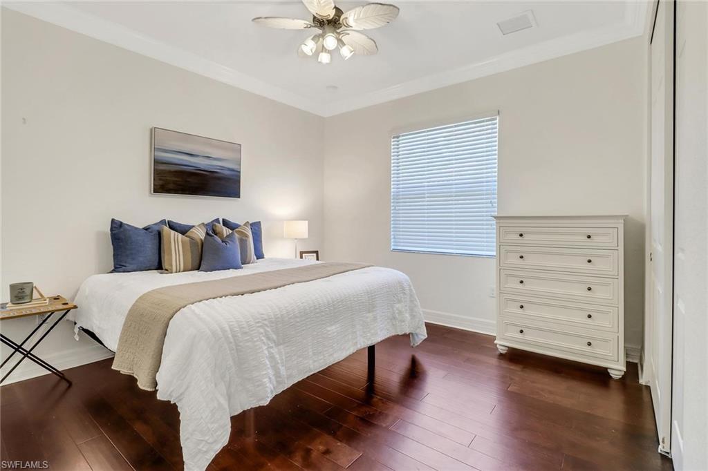 3260 Atlantic Circle Naples, FL 34119 - Photo 20 of 50 a bedroom with a bed and a chandelier