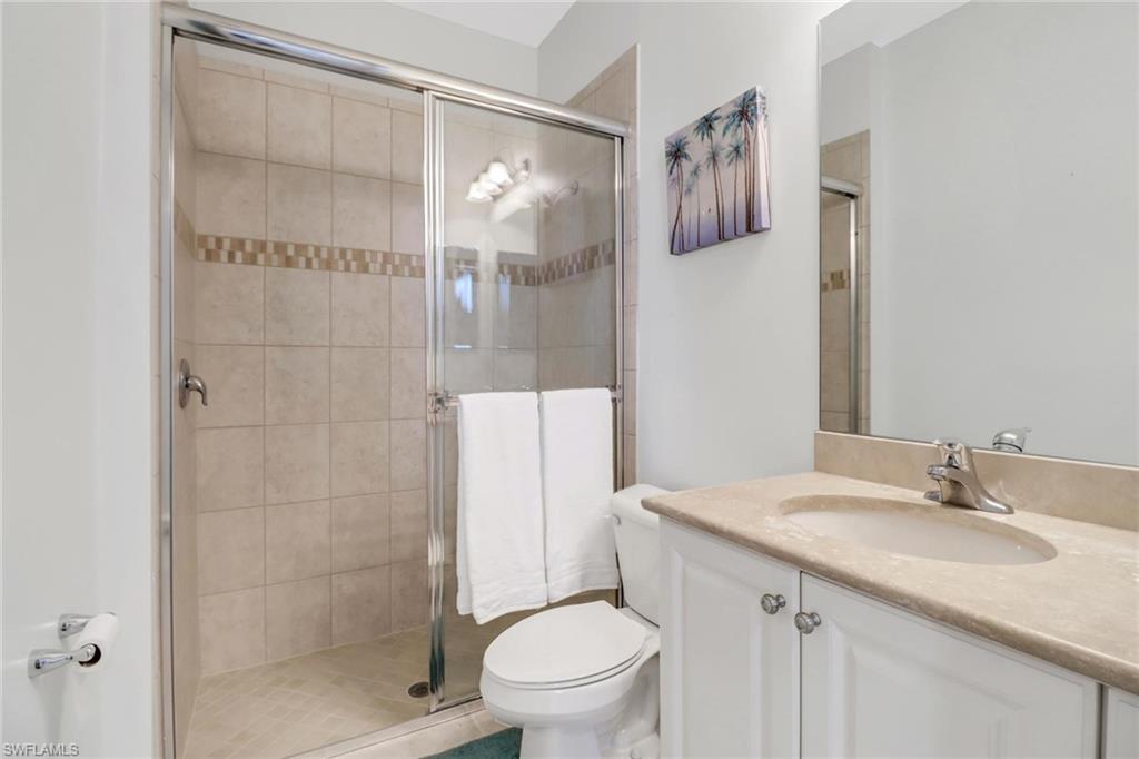 3260 Atlantic Circle Naples, FL 34119 - Photo 21 of 50 a bathroom with a granite countertop sink toilet and shower