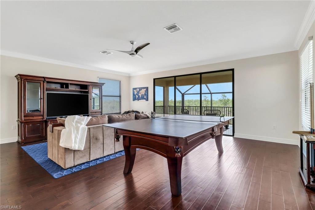 3260 Atlantic Circle Naples, FL 34119 - Photo 23 of 50 a living room with furniture a flat screen tv and a large window