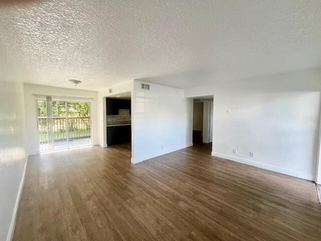 3440 Rudolph Road, Unit 4 Lake Worth, FL 33461 - Photo 4 of 9 an empty room with wooden floor and windows