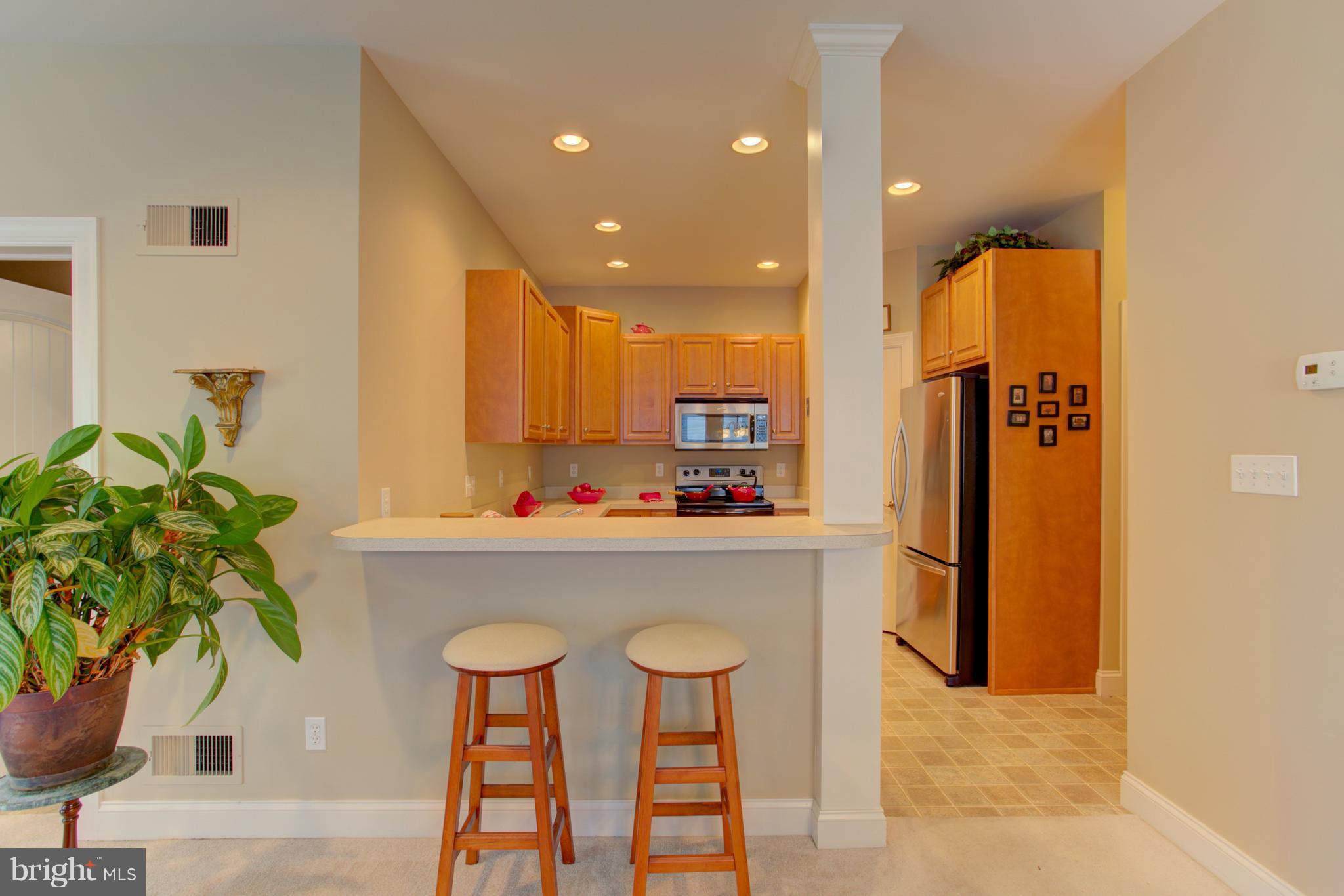 131 Baneberry Lane Lititz, PA 17543 - Photo 7 of 26 a kitchen with stainless steel appliances a dining table chairs in it and wooden floors