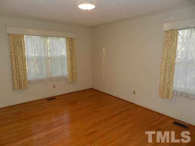 7209 Battle Bridge Road Raleigh, NC 27610 - Photo 14 of 21 an empty room with wooden floor and windows