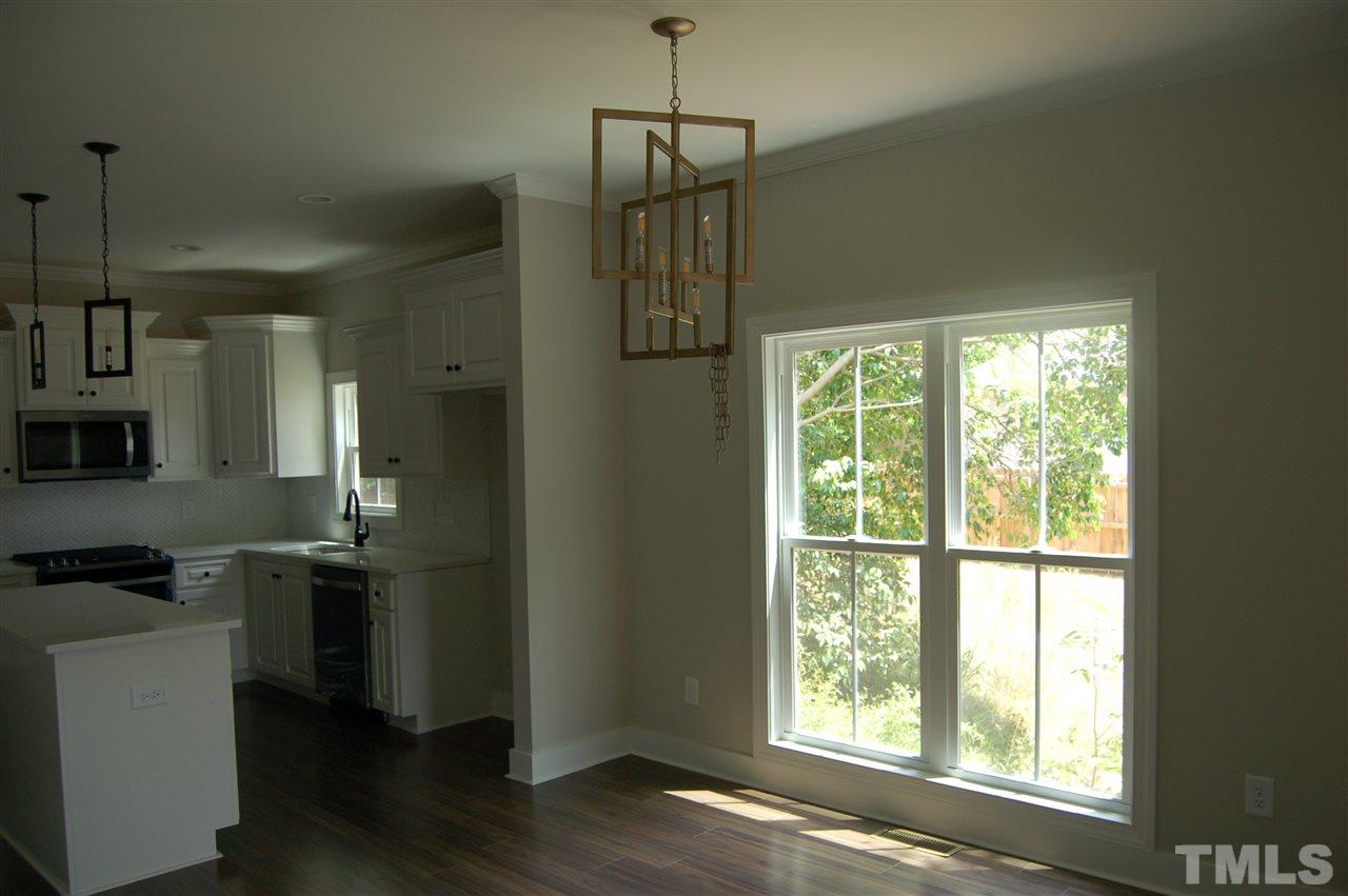 1433 Garner Road Raleigh, NC 27610 - Photo 12 of 23 a kitchen with stainless steel appliances a window and wooden floor