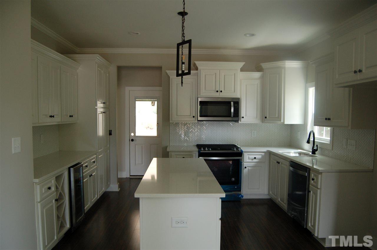 1433 Garner Road Raleigh, NC 27610 - Photo 13 of 23 a kitchen with stainless steel appliances a stove sink microwave and cabinets