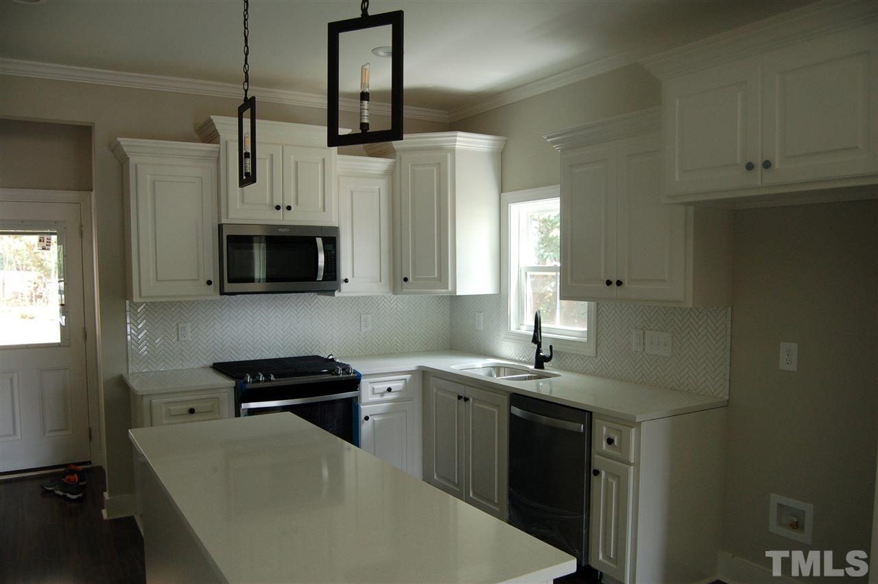 1433 Garner Road Raleigh, NC 27610 - Photo 14 of 23 a kitchen with stainless steel appliances a stove a sink and a microwave