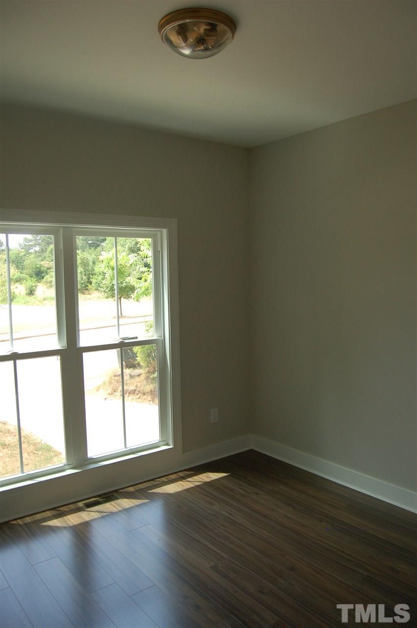 1433 Garner Road Raleigh, NC 27610 - Photo 7 of 23 a view of an empty room with wooden floor and a window