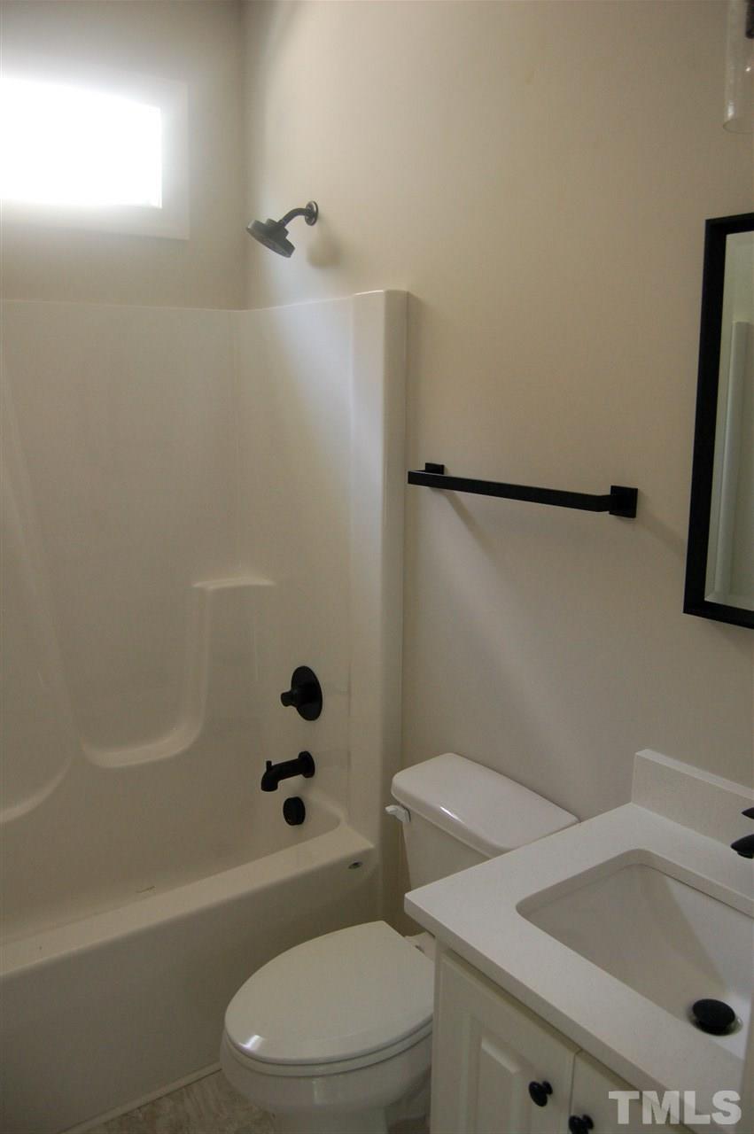 1433 Garner Road Raleigh, NC 27610 - Photo 10 of 23 a white toilet sitting next to a bath tub
