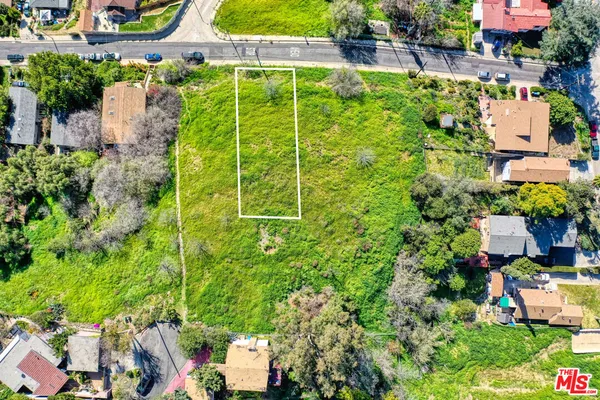 an aerial view of a house with a yard and lake view