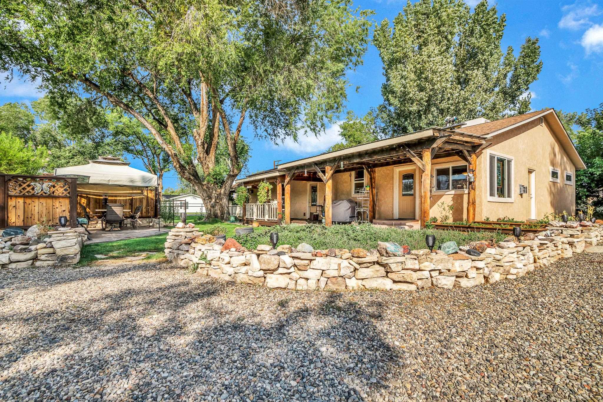 962-17 17 1/4 Road Fruita, CO 81521 - Photo 2 of 37 a front view of a house with a garden and trees