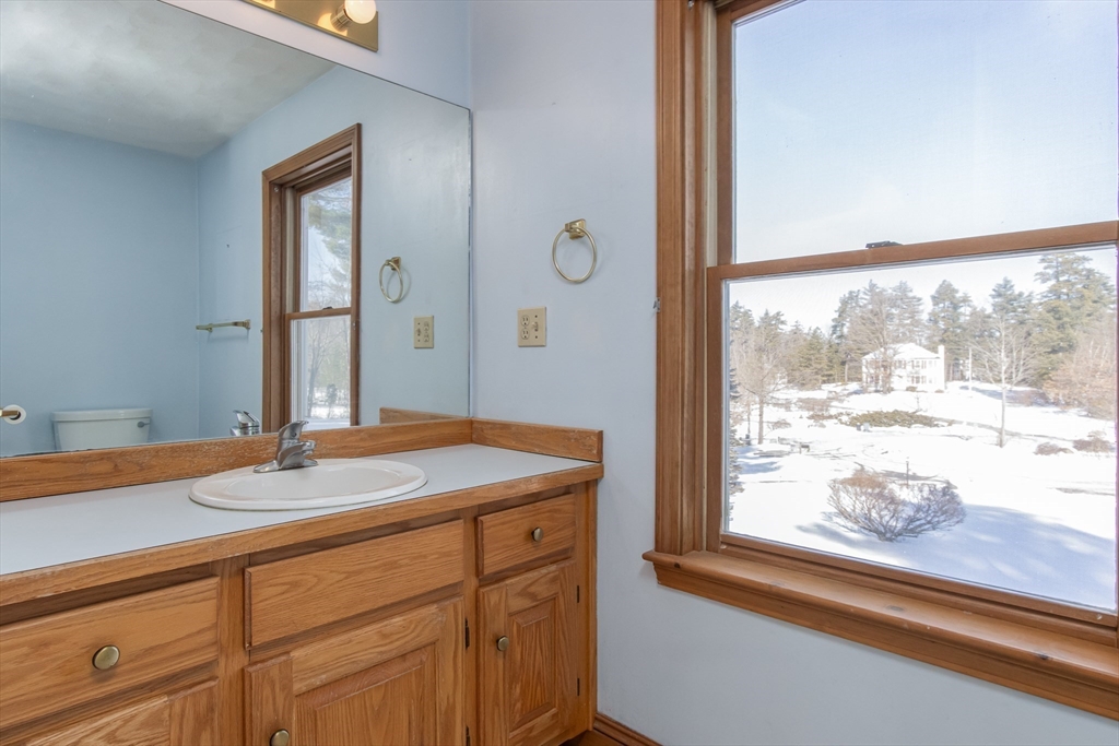 10 Ryan Road Townsend, MA 01474 - Photo 18 of 34 a bathroom with a sink and a large mirror next to a window