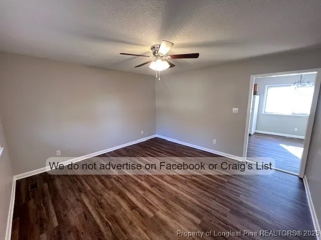 a view of a bedroom with wooden floor and fan