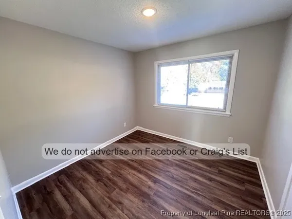 a view of a hall with wooden floor and a rug