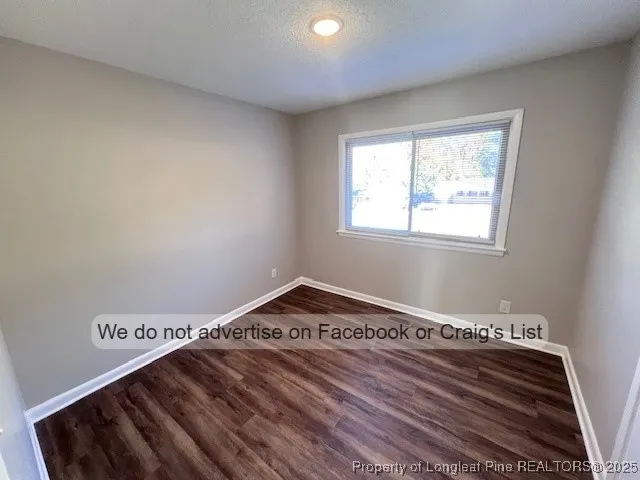 a view of a hall with wooden floor and a rug