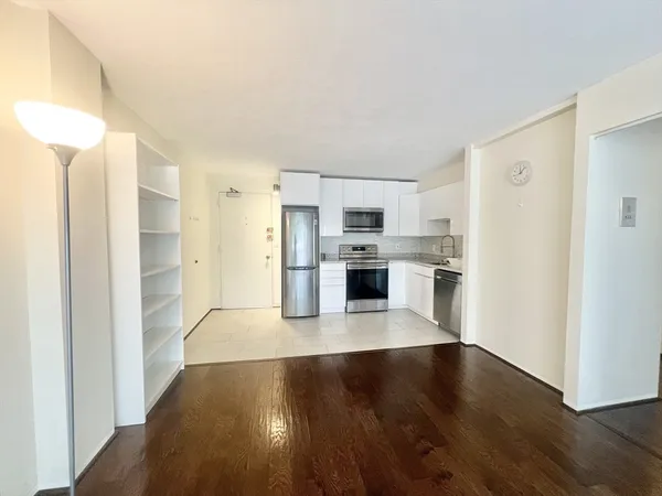 a kitchen with granite countertop a refrigerator and a stove top oven
