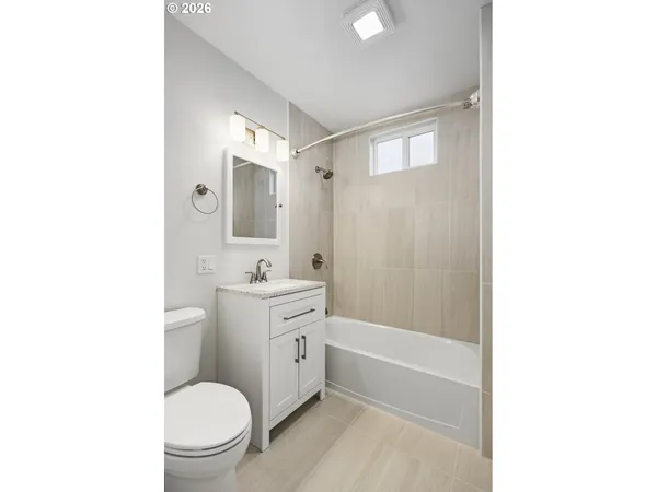 a bathroom with a granite countertop toilet a sink and a bathtub
