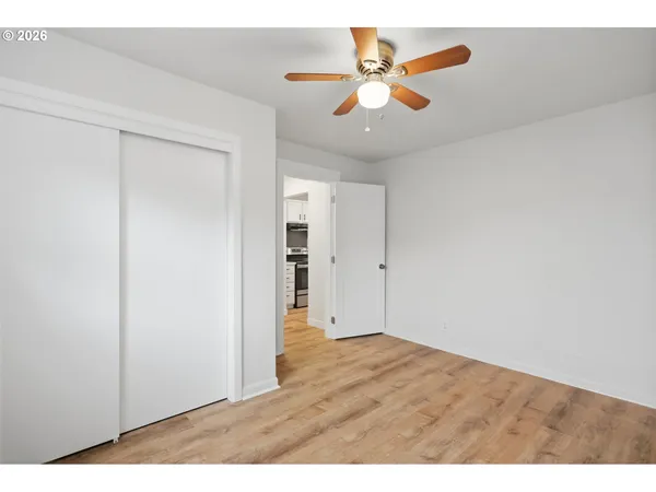an empty room with closet and a chandelier fan