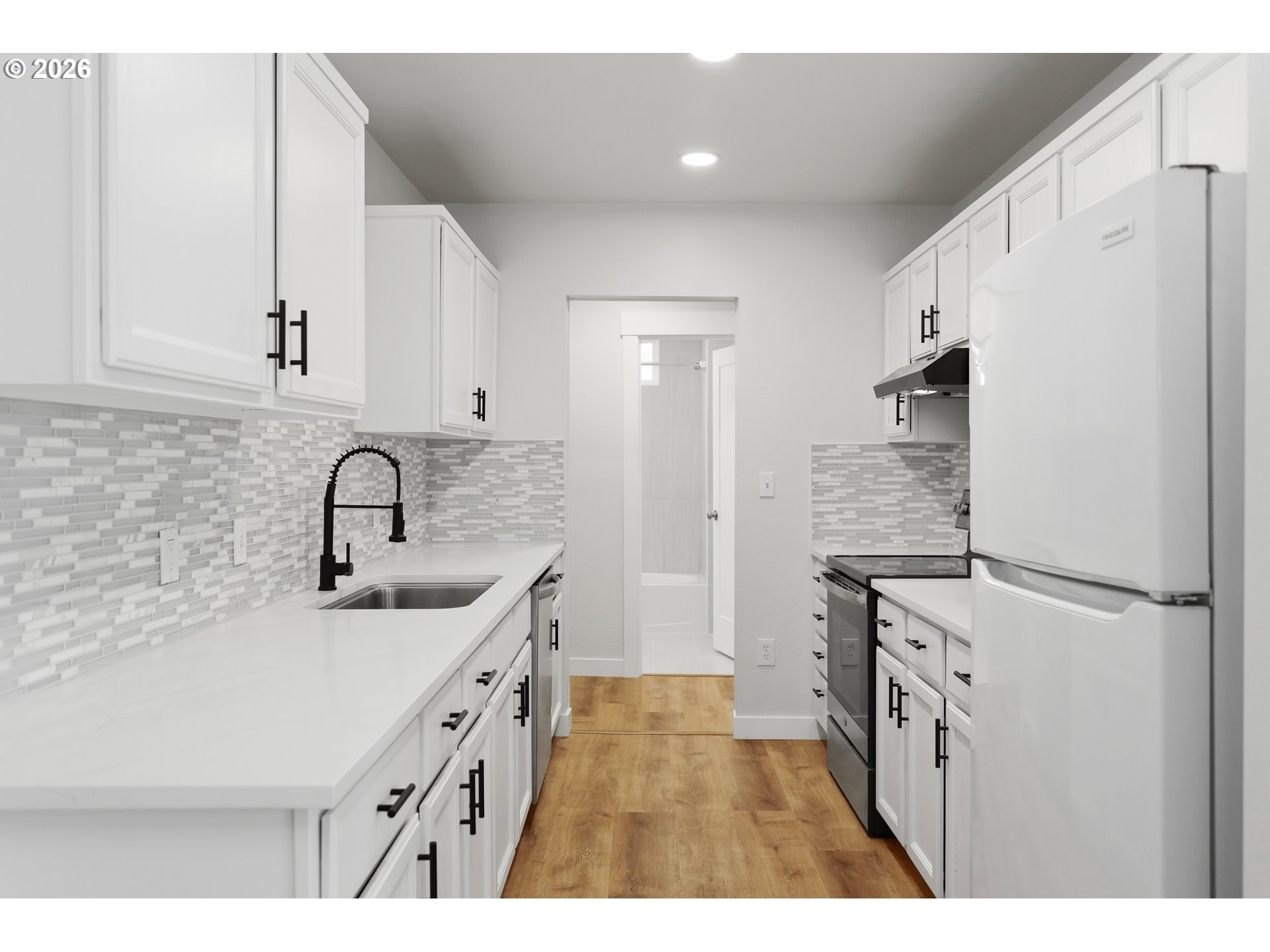 2306 West 13th Street The Dalles, OR 97058 - Photo 7 of 32 a kitchen with white cabinets and refrigerator