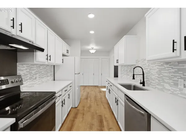 a kitchen with a sink and white cabinets