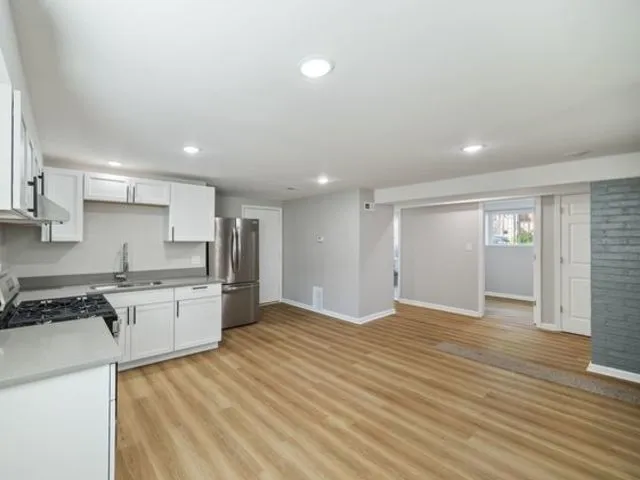 a large kitchen with kitchen island a sink stainless steel appliances and cabinets