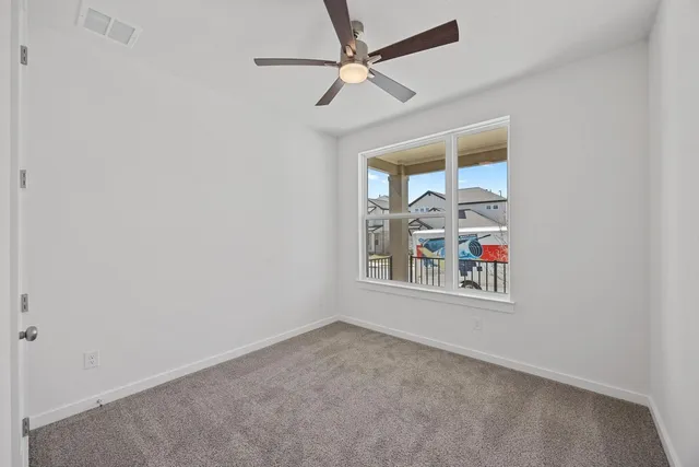 an empty room with fan and windows