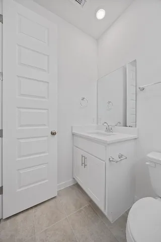 a bathroom with a sink vanity mirror and toilet