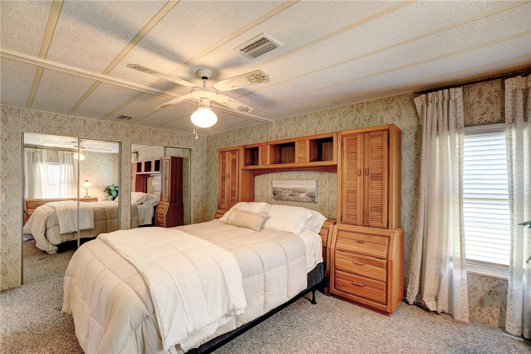 809 Oleander Circle Barefoot Bay, FL 32976 - Photo 11 of 29 a bedroom with bed and a chandelier