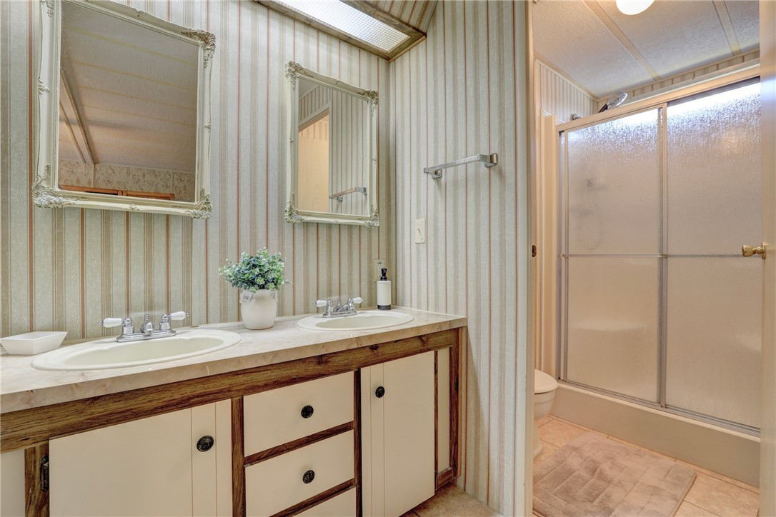 809 Oleander Circle Barefoot Bay, FL 32976 - Photo 12 of 29 a bathroom with a granite countertop sink and a mirror