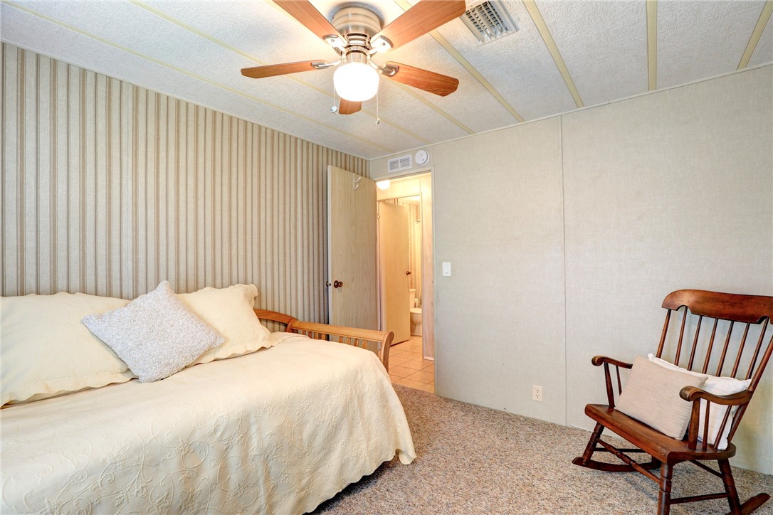 809 Oleander Circle Barefoot Bay, FL 32976 - Photo 14 of 29 a bedroom with a bed and a chair