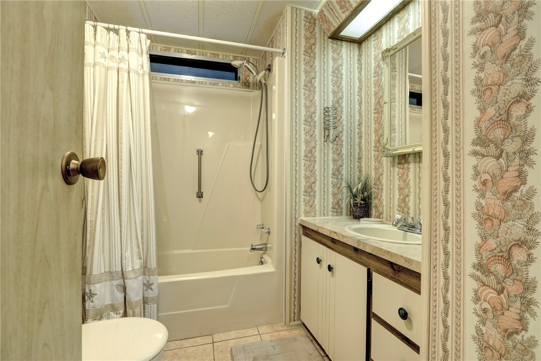 809 Oleander Circle Barefoot Bay, FL 32976 - Photo 15 of 29 a bathroom with a granite countertop sink toilet and shower
