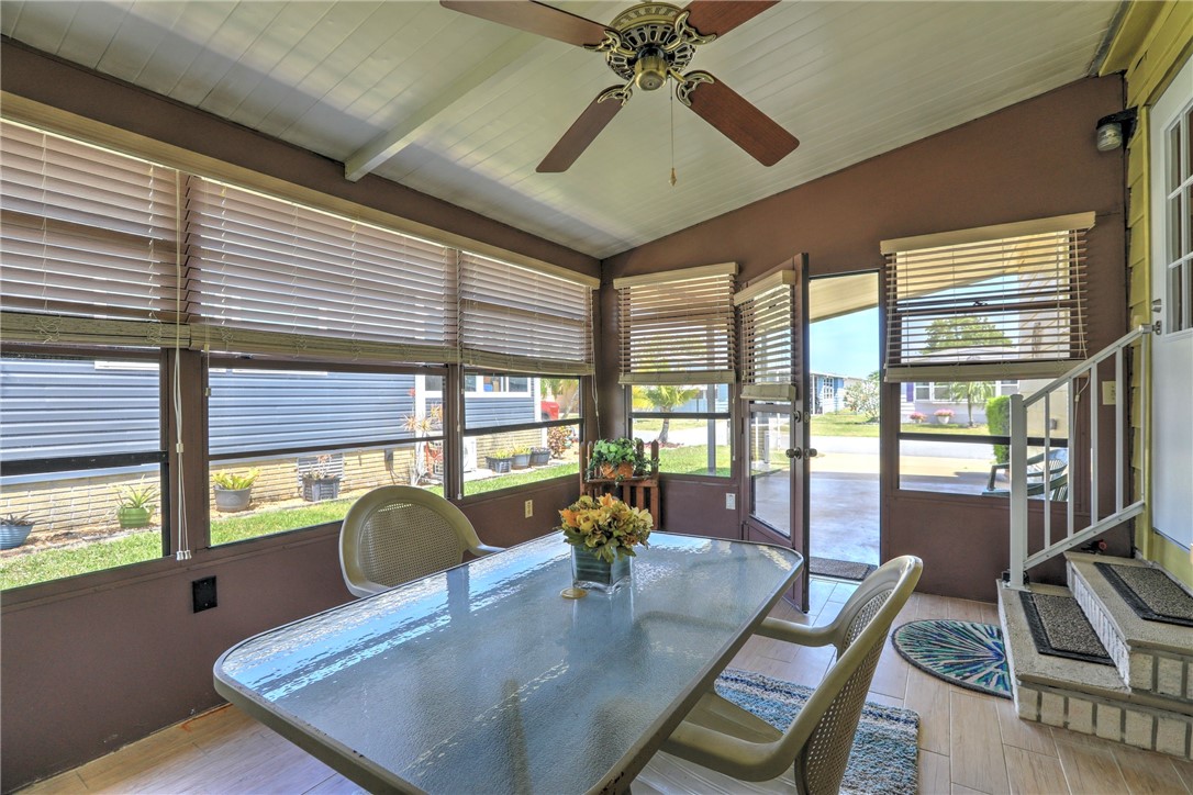 809 Oleander Circle Barefoot Bay, FL 32976 - Photo 18 of 29 a dining room with furniture a chandelier and wooden floor