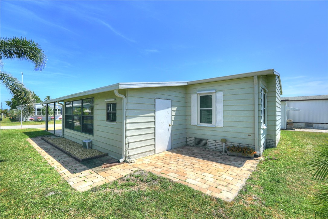 809 Oleander Circle Barefoot Bay, FL 32976 - Photo 4 of 29 a backyard of a house with yard and outdoor seating