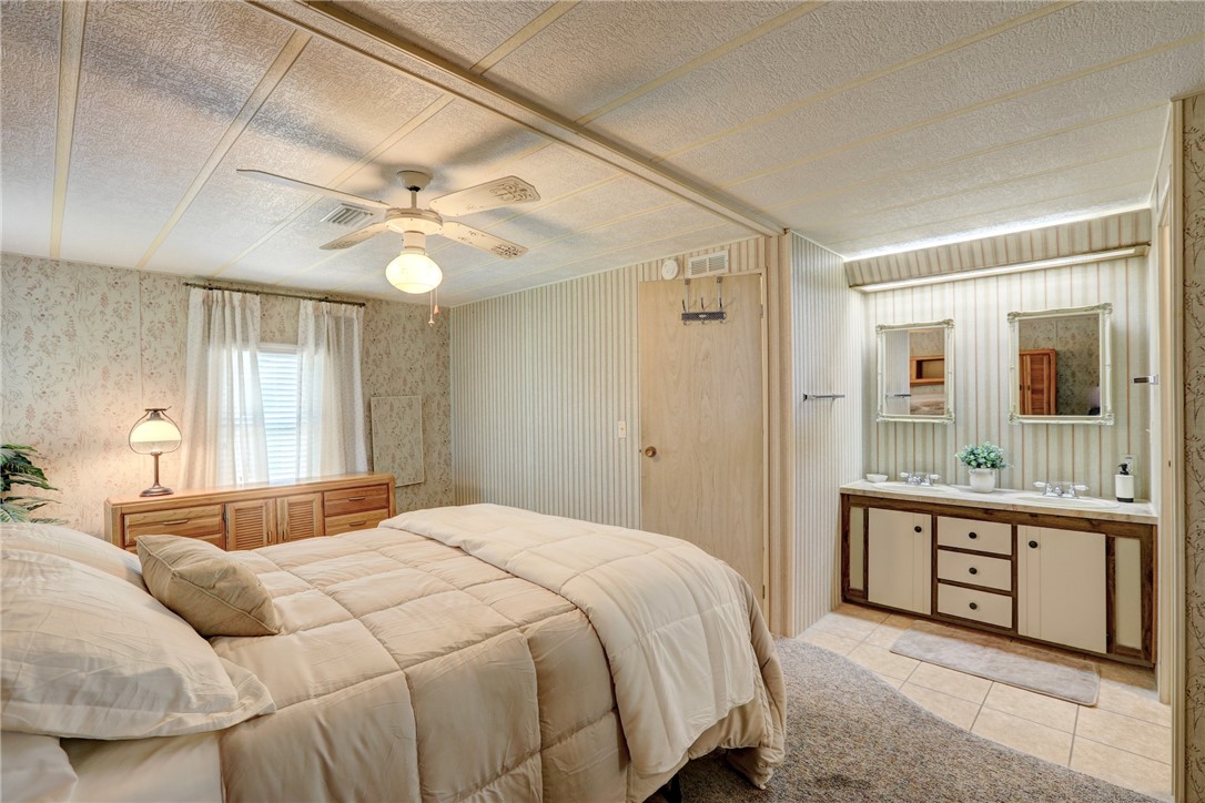 809 Oleander Circle Barefoot Bay, FL 32976 - Photo 10 of 29 a bedroom with a large bed and a chandelier