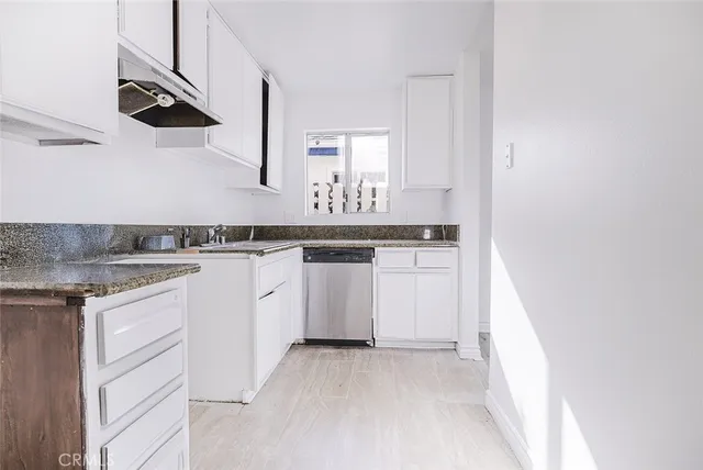 a kitchen with white cabinets stainless steel appliances and sink