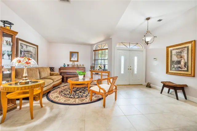 a living room with furniture a dining table and a chandelier