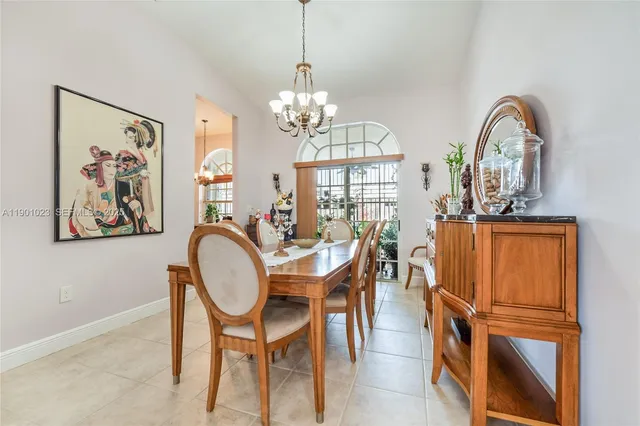 a view of a dining room with furniture a chandelier and wooden floor