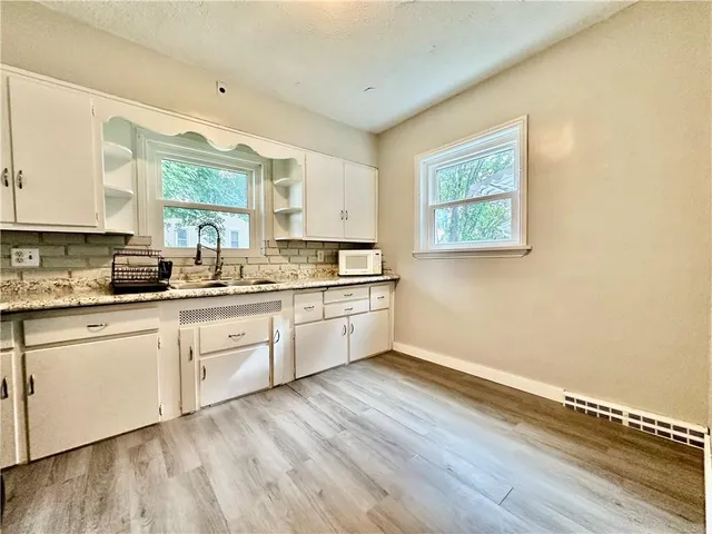 a view of a kitchen with wooden floor and electronic appliances