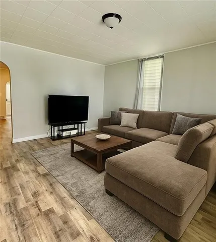 a view of a livingroom with wooden floor and a large window