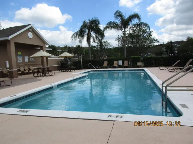 a view of a house with pool and sitting area