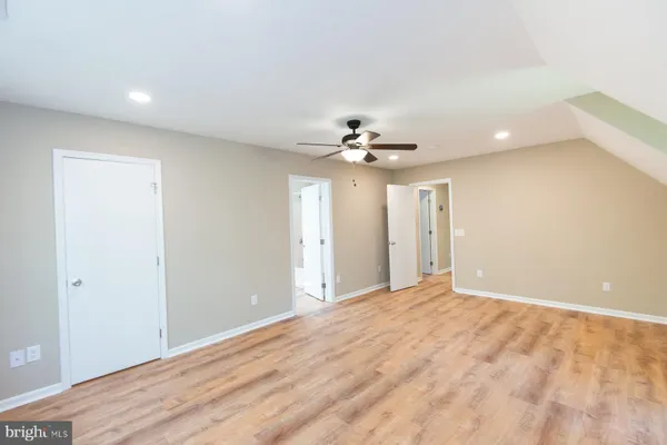a view of an empty room with a chandelier fan