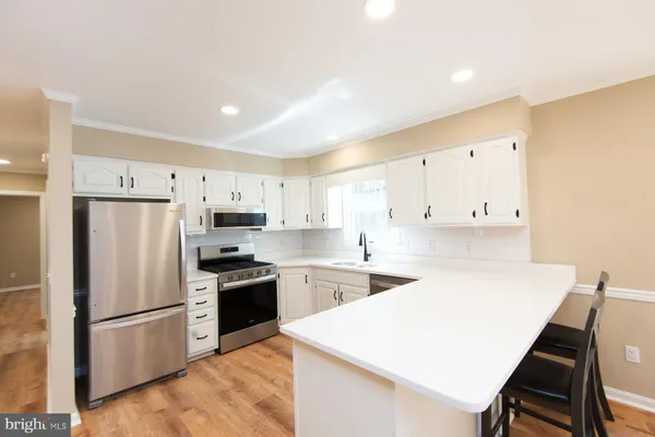 a kitchen with a white refrigerator a stove a sink and a refrigerator