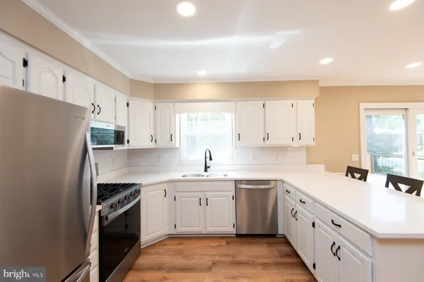 a kitchen with white cabinets stainless steel appliances and sink