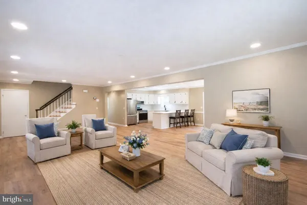 a living room with furniture and view of kitchen