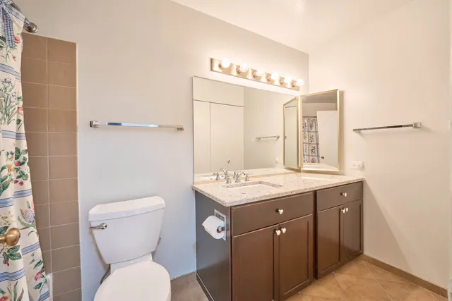 a spacious bathroom with a granite countertop sink a mirror and shower