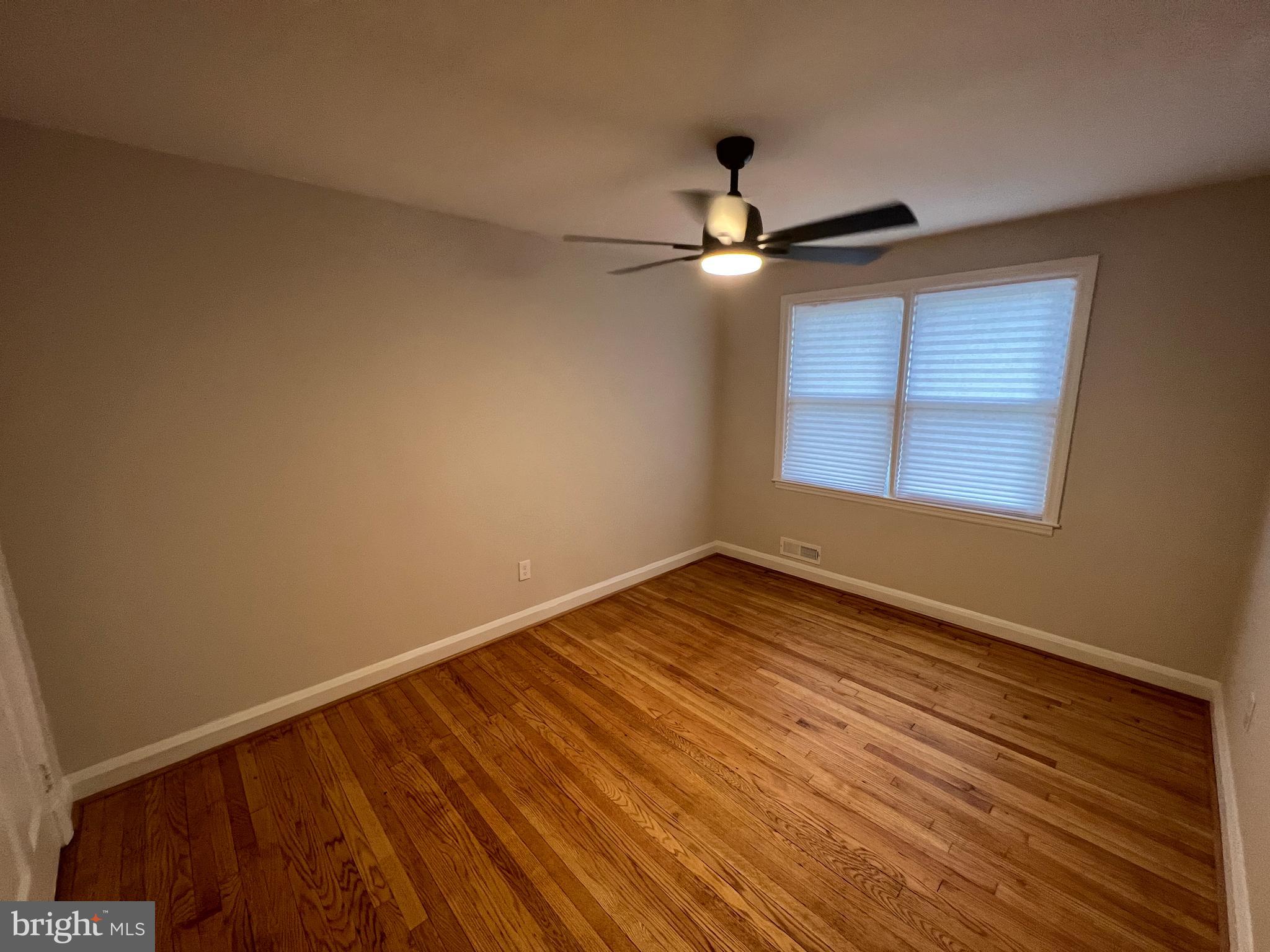 1655 Winford Road Baltimore, MD 21239 - Photo 19 of 44 an empty room with wooden floor fan and windows