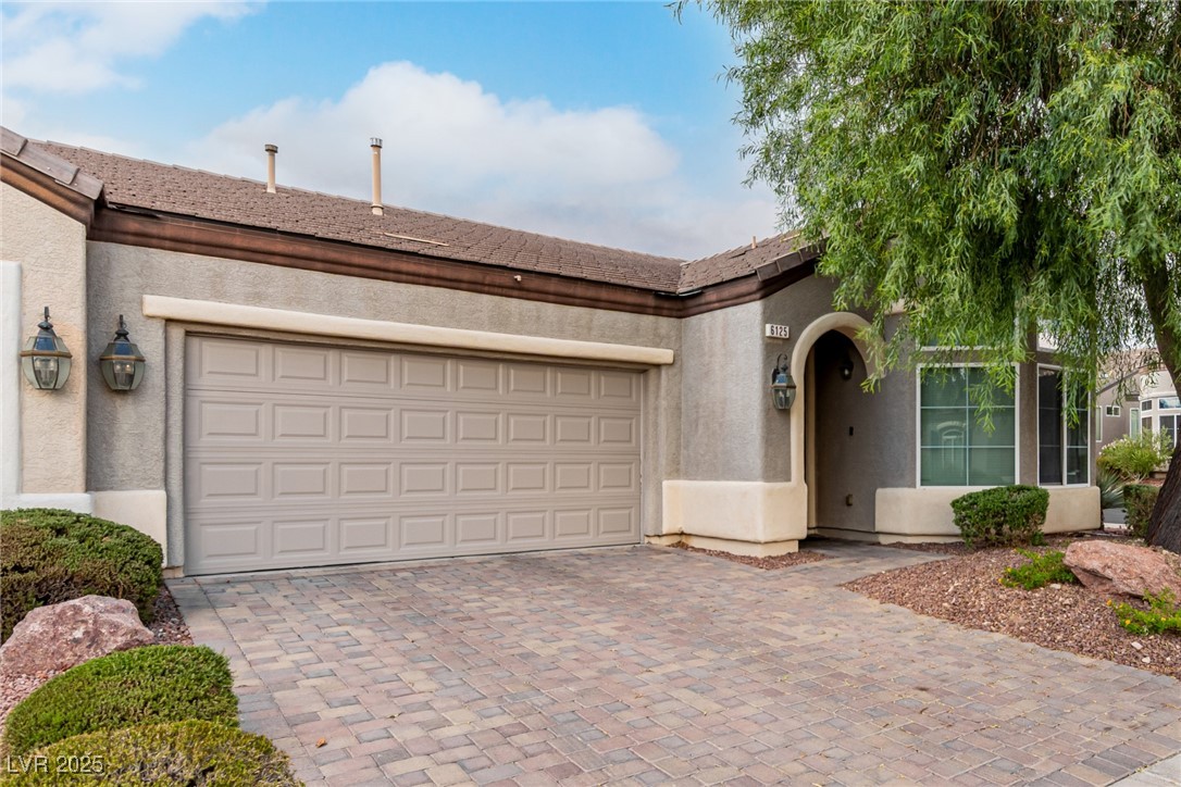 6125 Powdermill Street Las Vegas, NV 89148 - Photo 1 of 33 View of front of house featuring decorative driveway, stucco siding, and a garage
