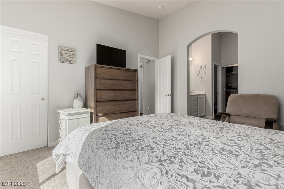 6125 Powdermill Street Las Vegas, NV 89148 - Photo 17 of 33 Bedroom with light carpet and arched walkways