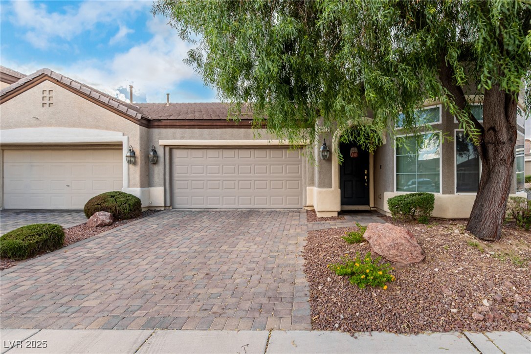 6125 Powdermill Street Las Vegas, NV 89148 - Photo 2 of 33 View of front facade featuring decorative driveway, stucco siding, and an attached garage