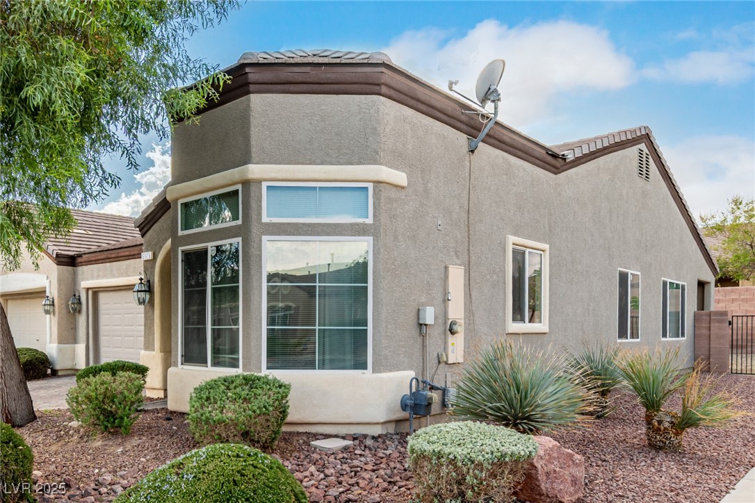 6125 Powdermill Street Las Vegas, NV 89148 - Photo 4 of 33 View of property exterior featuring stucco siding, a tile roof, and an attached garage